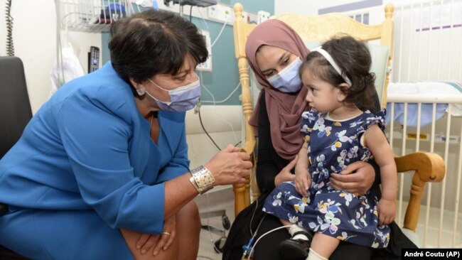  In this photo provided by the Children's Hospital of Eastern Ontario, Ayla Bashir and her mother, Sobia Qureshi, meet with Dr. Karen Fung Kee Fung, left, of the Ottawa Hospital in August 24, 2022. (André Coutu/CHEO via AP)