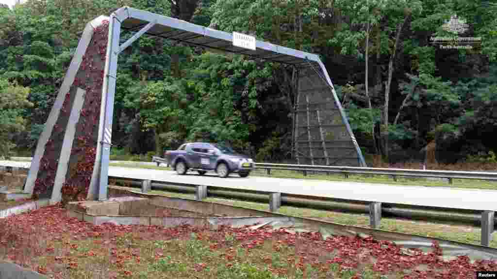 Red crabs climb a bridge over the road while crossing a street as part of their yearly migration, on Christmas Island, Australia, in this image obtained from an undated handout video.