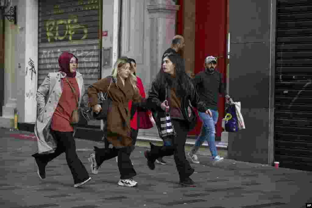 People leave the area after an explosion on Istanbul's popular pedestrian Istiklal Avenue Sunday, Istanbul, Turkey, Nov. 13, 2022. 