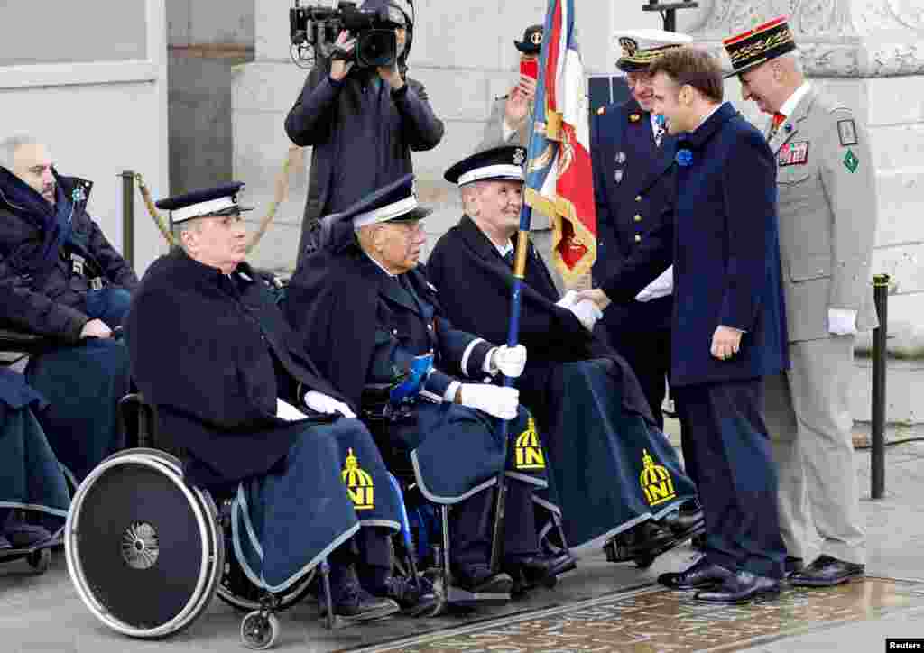 France's President Emmanuel Macron greets veterans during a ceremony at the Arc de Triomphe in Paris as part of commemorations marking the 104th anniversary of the November 11, 1918, Armistice, ending World War I.