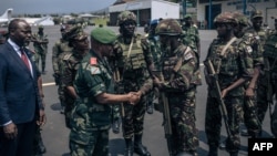 The governor of the North-Kivu Province, General Constant Ndima, third from left, greets Kenyan army troops as they land at Goma airport, eastern Democratic Republic of Congo, Nov. 12, 2022.