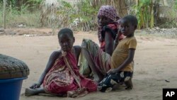 FILE - In this video image, residents watch as Rwandan soldiers patrol a village in Cabo Delgado province, Mozambique, Aug. 9, 2021. The U.N. says it needs an immediate infusion of funds to continue to help feed 1 million people displaced by conflict.