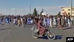 This image grab from a UGC video posted on Nov. 11, 2022, shows protesters holding signs and chanting slogans during a march in Khash, in Iran's southeastern province of Sistan-Baluchistan. (Photo by UGC /AFP)