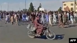 FILE - This image grab from a UGC video posted Nov. 11, 2022, shows protesters holding signs and chanting slogans during a march in Khash, in Iran's Sistan-Baluchistan province. (UGC/AFP)