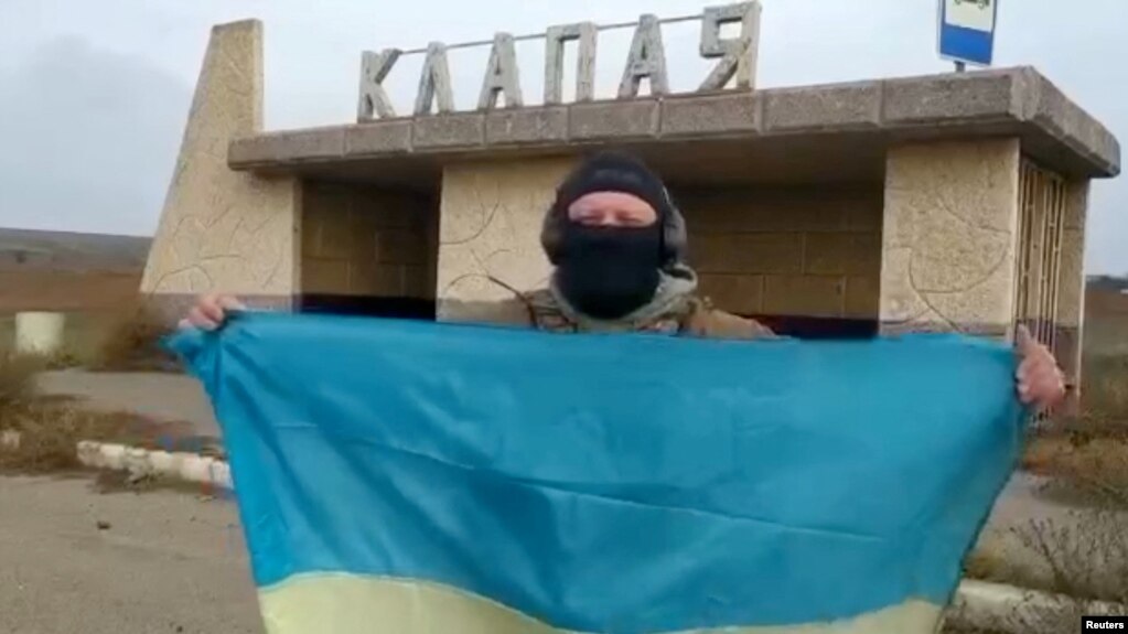 一名乌克兰士兵在南部赫尔松地区的一个村庄里展示乌克兰国旗。（2022年11月11日）