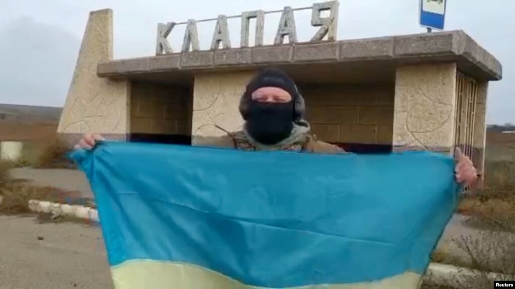 一名乌克兰士兵在南部赫尔松地区的一个村庄里展示乌克兰国旗。（2022年11月11日）(photo:VOA)