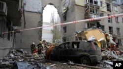 Ukrainian Emergency Service rescuers work at the scene of a building damaged by night shelling in Mykolaiv, Ukraine, Nov. 11, 2022.