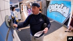 Anthony Bruno, a student at the Washington Junior High School, uses the unlocking mechanism as he leaves classes for the day to open the bag that his cell phone was sealed in during the school day, Thursday, Oct. 27, 2022. (AP Photo/Keith Srakocic)