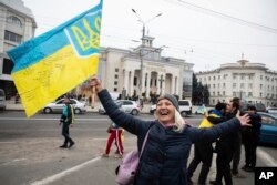 Ukrainians gather in downtown to celebrate the recapturing of their city Kherson, Ukraine, Saturday, Nov. 12, 2022. (AP Photo/Yevhenii Zavhorodnii)