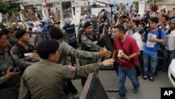 Riot police officers stop journalists from entering a blocked main street near the Cambodia National Rescue Party (CNRP) headquarters, on the outskirts of Phnom Penh, Cambodia, Monday, May 30, 2016. Police in Cambodia blocked an opposition protest march o