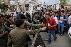 FILE -Riot police officers stop journalists from entering a blocked main street near the Cambodia National Rescue Party (CNRP) headquarters, on the outskirts of Phnom Penh, Cambodia, Monday, May 30, 2016.