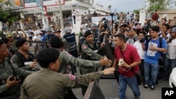 FILE PHOTO - Riot police officers stop journalists from entering a blocked main street near the Cambodia National Rescue Party (CNRP) headquarters, on the outskirts of Phnom Penh, Cambodia, Monday, May 30, 2016. 