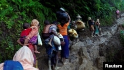 Rohingya refugees climb up a hill after crossing the Bangladesh-Myanmar border in Cox's Bazar, Bangladesh, Sept. 8, 2017.