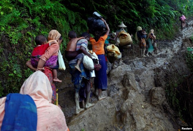 FILE - Rohingya refugees climb up a hill after crossing the Bangladesh-Myanmar border in Cox's Bazar, Bangladesh, Sept. 8, 2017.