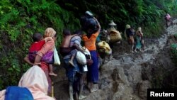 Pengungsi Rohingya mendaki bukit setelah menyeberangi perbatasan Bangladesh-Myanmar border di Cox's Bazar, Bangladesh, 8 September 2017. 