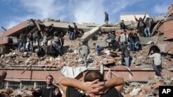 People try to save others trapped under debris in Tabanli village near the city of Van after a powerful earthquake struck eastern Turkey, October 23, 2011.