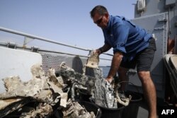 A staff member of the U.S. agency the Defense POW/MIA Accounting Agency inspects, July 2, 2018, fragments of the USAAF P-47 Thunderbolt U.S. fighter plane, that crashed during World War II, off the French Mediterranean island of Corsica.