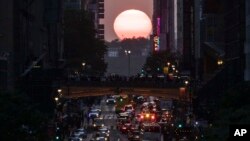 "Manhattanhenge" olarak bilinen gün batımının gökdelenler arasında hizalanması New York'ta 42. caddedeki binaların arasından gözüküyor- 30 Mayıs 2023.