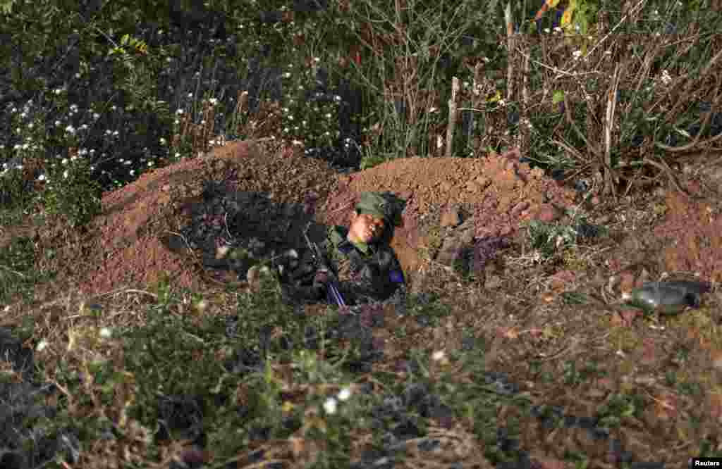 A rebel soldier of the Myanmar National Democratic Alliance Army (MNDAA) sleeps with his rifle inside a trench near a military base in Kokang region March 10, 2015. Fighting broke out last month between Myanmar&#39;s army and MNDAA, which groups remnants of the Communist Party of Burma, a powerful Chinese-backed guerrilla force that battled Myanmar&#39;s government before splintering in 1989.