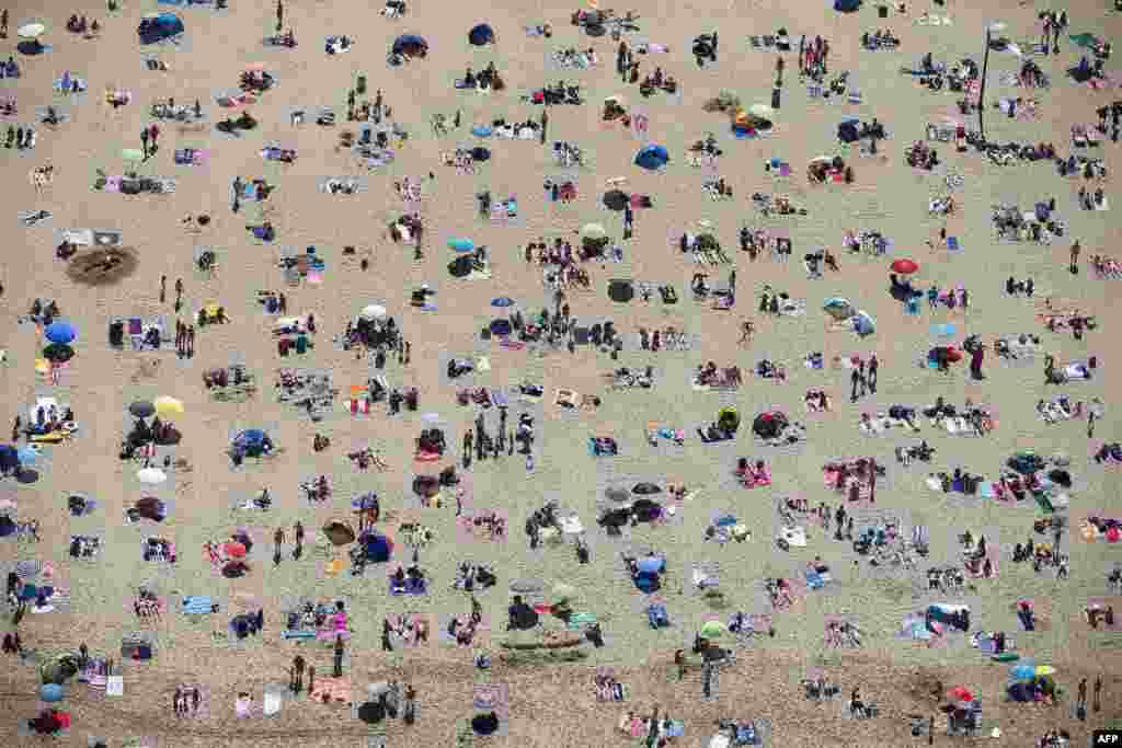 An aerial view of sunbathers crowding on the beach in Scheveningen, the Netherlands, during a warm summer day.