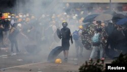 12일 홍콩 입법부 밖에서 경찰들이 '범죄인인도조례' 개정안에 반대하는 시위대를 향해 최루탄을 발사하자 시위 참가자들이 흩어지고 있다.