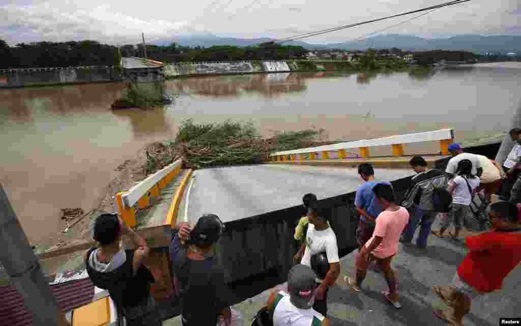 Residents inspect a bridge destroyed during the onslaught of Typhoon Rammasun in Batangas city south of Manila, July 17, 2014.