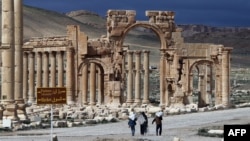 A picture taken on March 14, 2014 shows Syrian citizens walking in the ancient oasis city of Palmyra, 215 kilometres northeast of Damascus. 