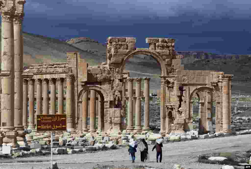 Syrian citizens walking in the ancient oasis city of Palmyra, 215 kilometres northeast of Damascus.