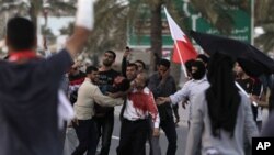 An unidentified Bahraini anti-government protester is carried to a vehicle to be taken to a hospital after being shot during a demonstration in Manama, February 18, 2011