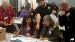  Election officials in Newport News, Virginia, examine ballots that a computer failed to scan during a recount for a House of Delegates race on Dec. 19, 2017.