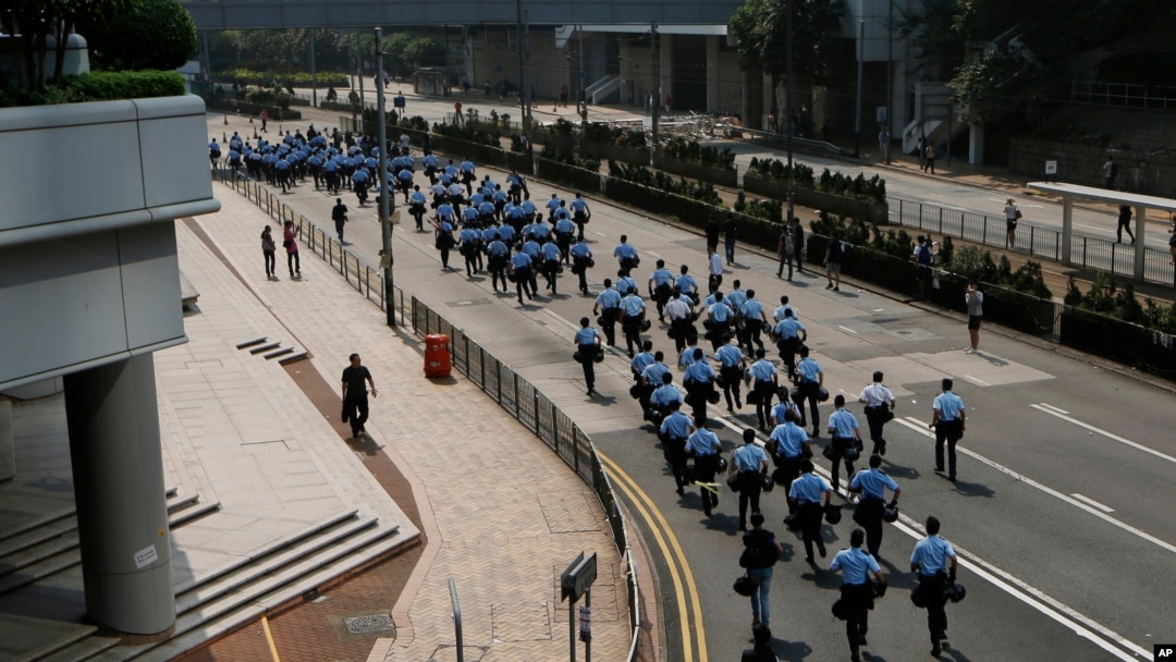 Polisi Hong Kong membersihkan barikade-barikade yang dipasang demontran pro-demokrasi (14/10).