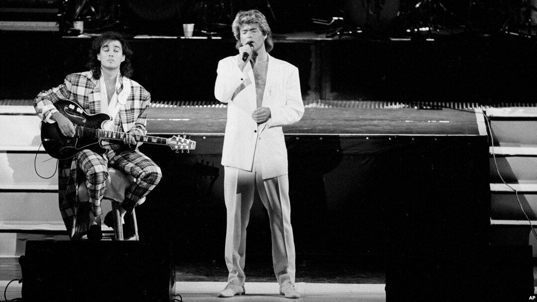 FILE - George Michael and Andrew Ridgeley of the British group WHAM! perform during a concert in Peking, China, April 7, 1985.