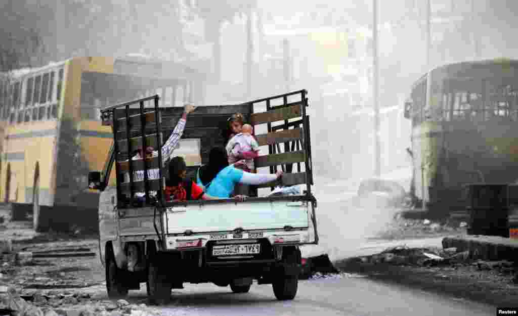 A family in a pick-up truck flees violence in the city of Aleppo October 17, 2012. 