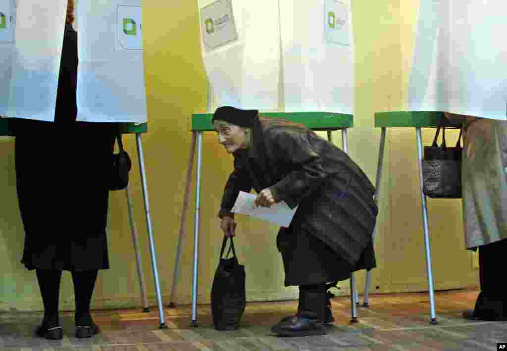 A woman she leaves a voting booth during the presidential election in Tbilisi, Oct. 27, 2013.