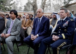 FILE - U.S. envoy for peace in Afghanistan Zalmay Khalilzad, center, and U.S. Army General Scott Miller, commander of NATO's Resolute Support Mission, attend President Ashraf Ghani's inauguration, in Kabul, March 9, 2020.