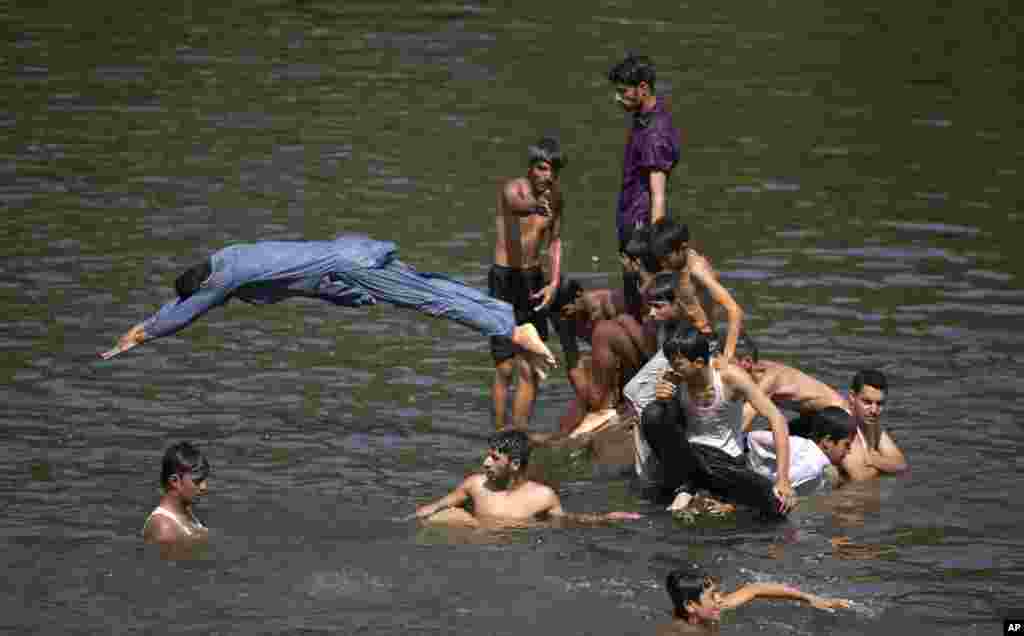 Warga mendinginkan diri di sungai saat suhu udara mencapai 38&deg; C pada hari bulan Ramadan di Islamabad, Pakistan.&nbsp;