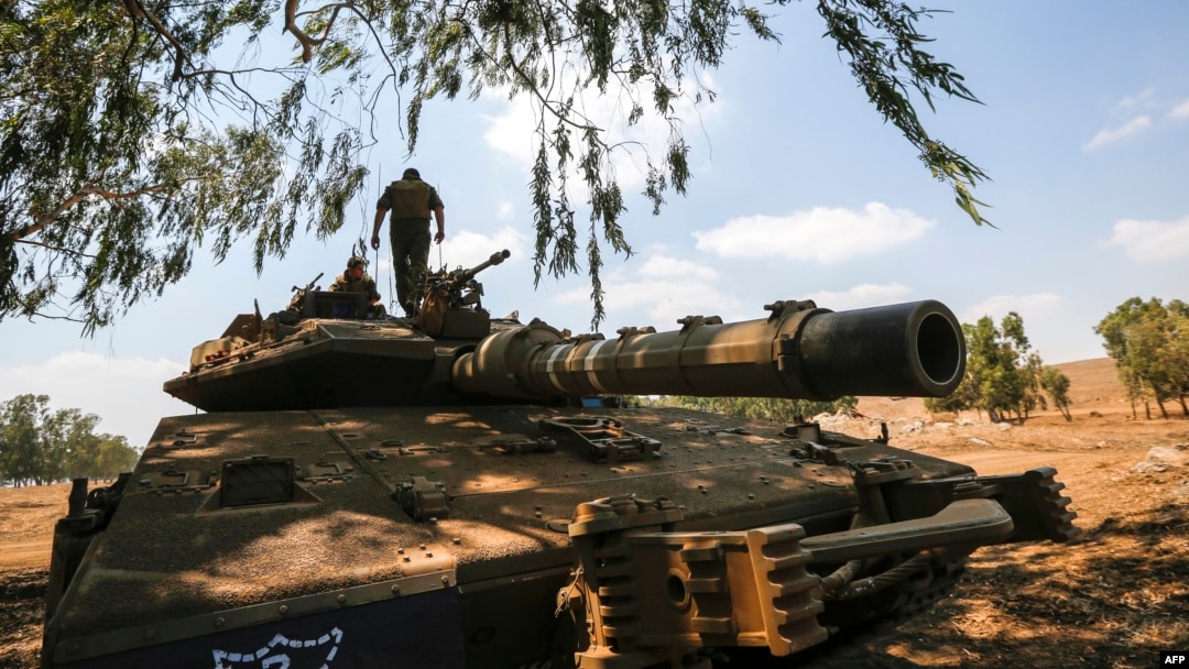 Seorang tentara Israel di atas tank tempur Merkava saat mengikuti latihan militer di Dataran Tinggi Golan di perbatasan dengan Suriah, 8 Agustus 2018. (Foto:AFP)