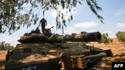 Seorang tentara Israel di atas tank tempur Merkava saat mengikuti latihan militer di Dataran Tinggi Golan di perbatasan dengan Suriah, 8 Agustus 2018. (Foto:AFP)