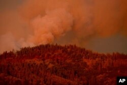 FILE - The Ferguson Fire burns along a ridgeline in unincorporated Mariposa County, Calif, July 16, 2018.