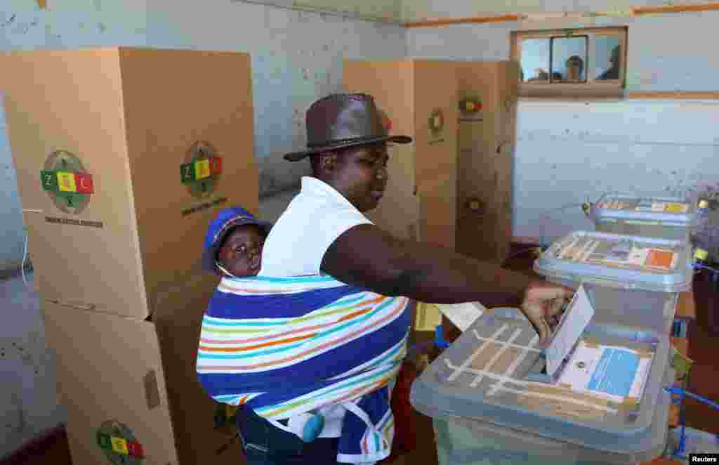 A woman with a baby on her back casts her ballot in the country's general elections in Harare, Zimbabwe, July 30, 2018.