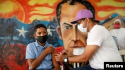Un estudiante de una escuela pública recibe una dosis de la vacuna Sinopharm contra el COVID-19, como parte de una campaña de vacunación para adolescentes, en Caracas, Venezuela, el 27 de octubre de 2021.