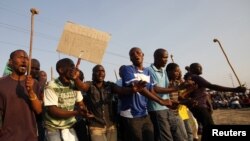 Pekerja tambang platina Marikana di Lonmin, Afrika Selatan, berdemonstrasi menentang polisi. (Foto: Dok)