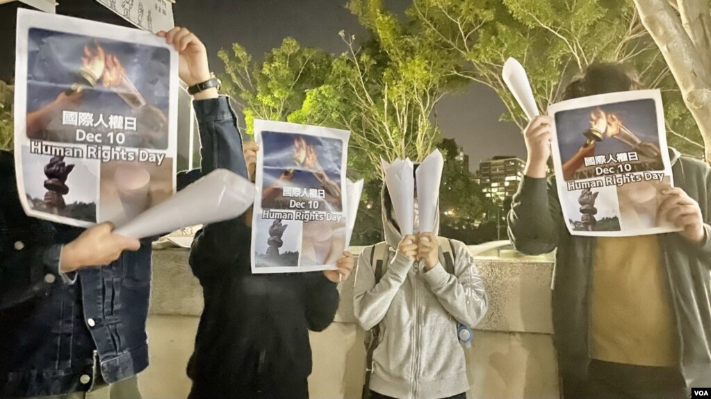 4名中国内地留学生12月10日国际人权日，在香港中文大学校园内举起白纸火炬及标语，呼吁各界关注中国内地“白纸示威”被捕人士，敦促当局尽快放人 (美国之音/汤惠芸)(photo:VOA)