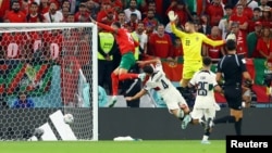 Morocco's Youssef En-Nesyri scores the opening goal against Portugal at the 2022 FIFA World Cup