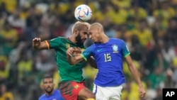 Brazil's Fabinho, right, and Cameroon's Eric Maxim Choupo-Moting jump for the ball during their World Cup group G soccer match at Lusail Stadium in Lusail, Qatar, Dec. 2, 2022.