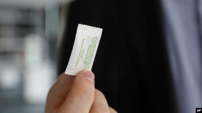 In this photo taken Monday, Oct. 24, 2022, in Chicago, Patrick Flynn, a co-founder of Hazel Technologies, holds a sachet designed to slow the ripening of process of various fruits. (AP Photo/Martha Irvine)