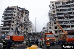 Emergency personnel work at the site where an apartment block was heavily damaged by a Russian missile strike in Dnipro, Ukraine, Jan. 15, 2023.