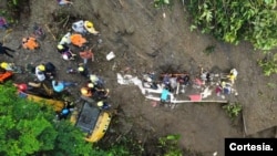 Un grupo de socorristas y voluntarios trabajan para sacar de la tierra los cuerpos de las personas que continúan dentro de un autobús arrastrado por un deslave en Colombia el 5 de diciembre de 2022. Foto cortesía del Ministerio de Defensa de Colombia. 