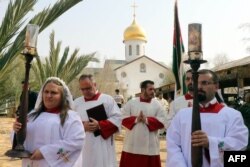 FILE - Christian clerics attend an annual pilgrimage to Bethany beyond the Jordan river, the site where many believe Jesus Christ was baptized, west of the Jordanian capital Amman, Jan. 12, 2018.
