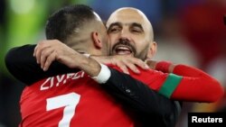 Morocco's coach Walid Regragui hugs his player Hakim Ziyech who scored the final penalty against Spain at the 2022 FIFA World Cup
